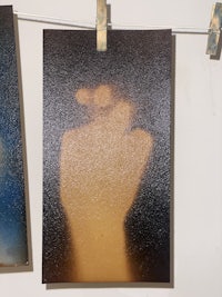 two pictures of a hand hanging on a wall